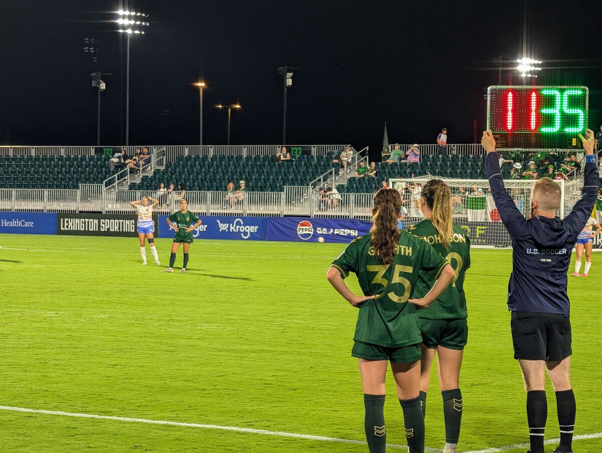 Players and referee on the field during a night match
